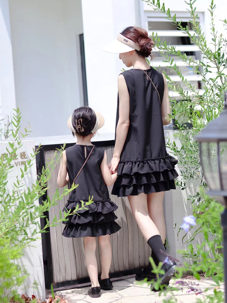 Mother and daughter in coordinated black ruffle dresses for a stylish day out